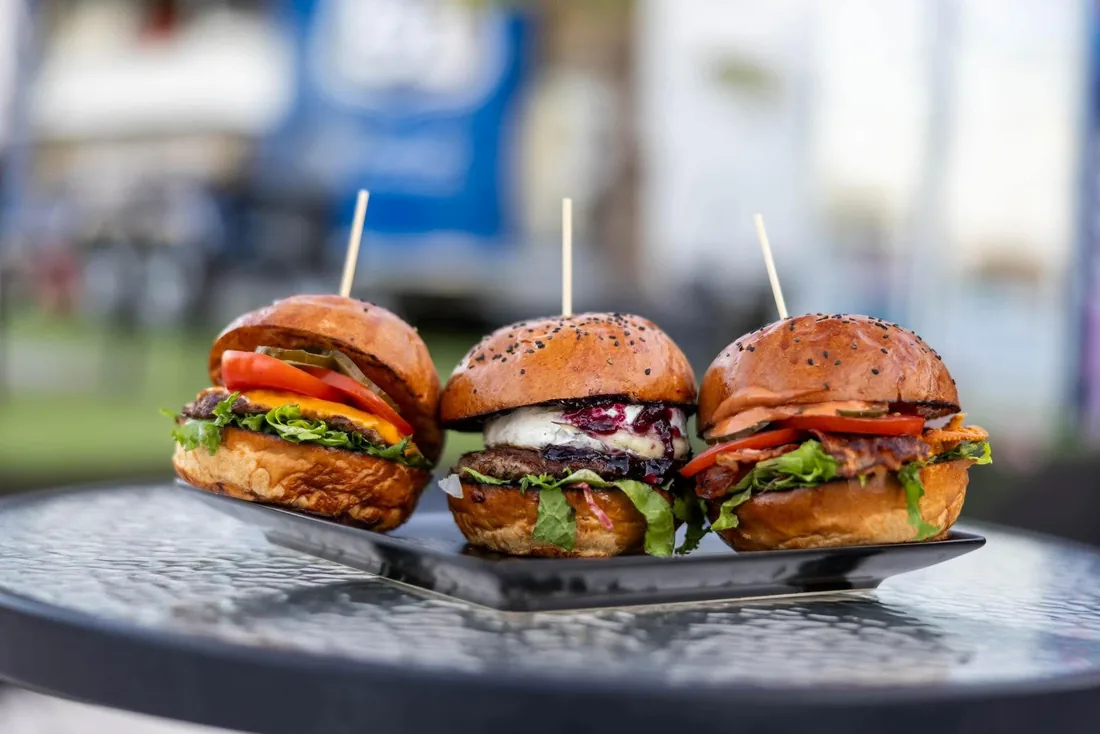 Három mini burger egy soron, friss zöldségekkel, a YARD 51 udvarán