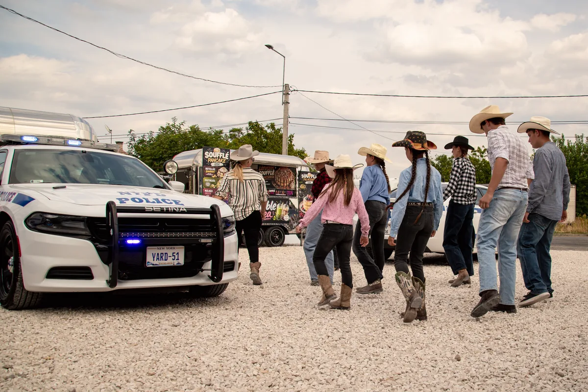 Country táncosok cowboykalapban a YARD 51 rendőrautója mellett
