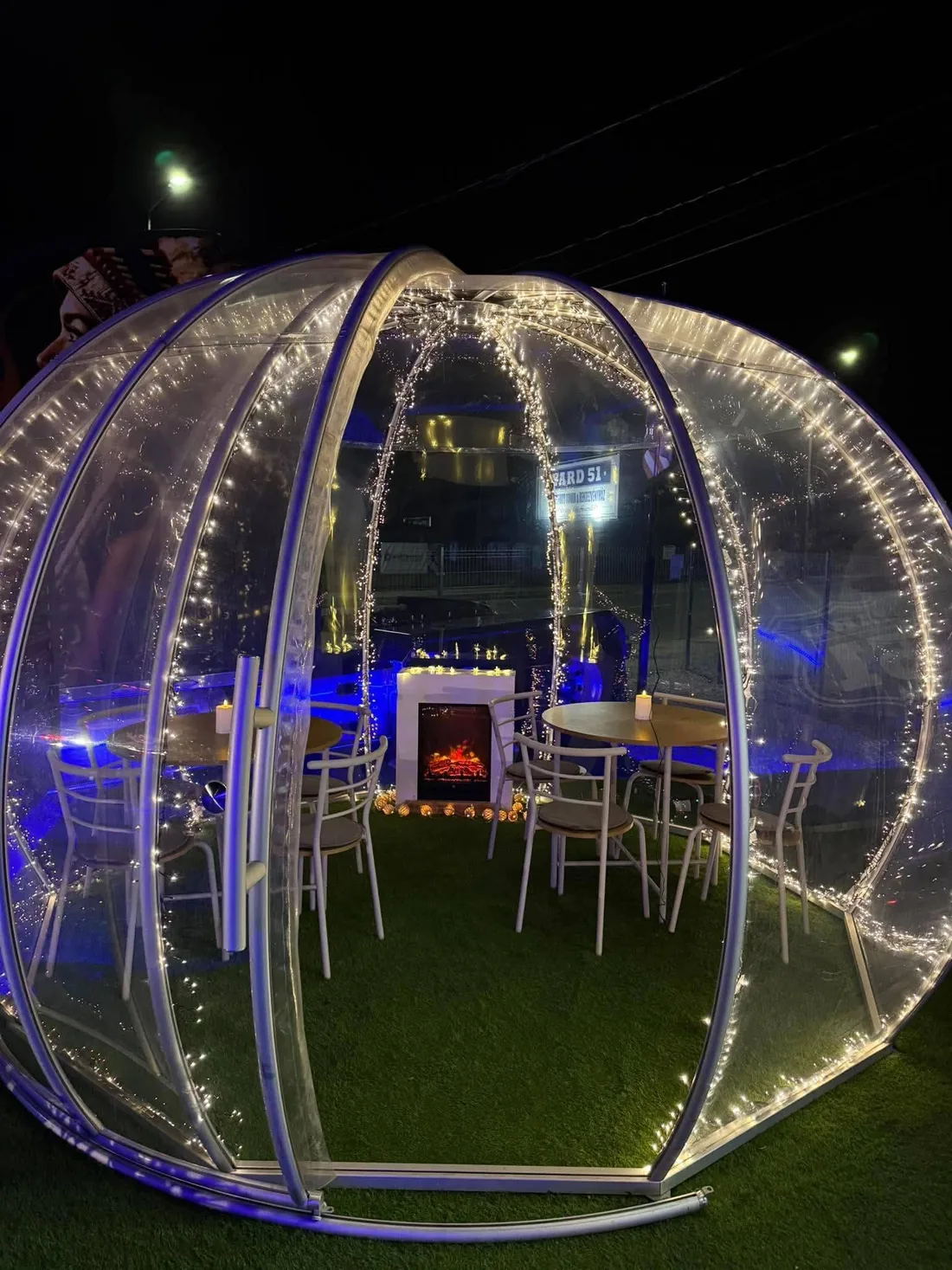 Kivilágított igloo a YARD 51 kertjében, kandallóval és asztalokkal