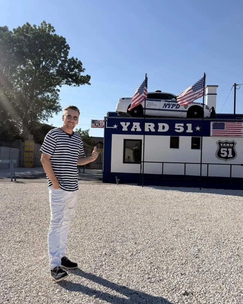 A YARD 51 épülete nappal, tetején az NYPD rendőrautóval és amerikai zászlókkal
